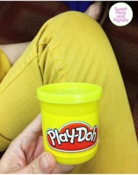 Holding Play-doh by yellow pants